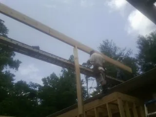 Carpenter setting a ridge beam over a new addition frame — Ice Dam Removal by Roofing Brothers in Kinsman