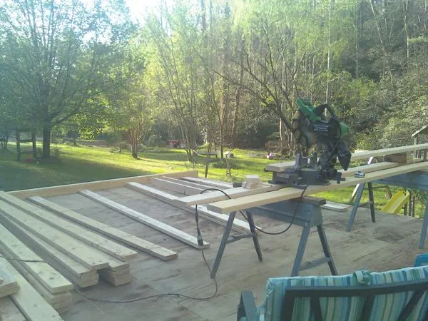 Miter saw and framing lumber on a deck under construction in Kinsman